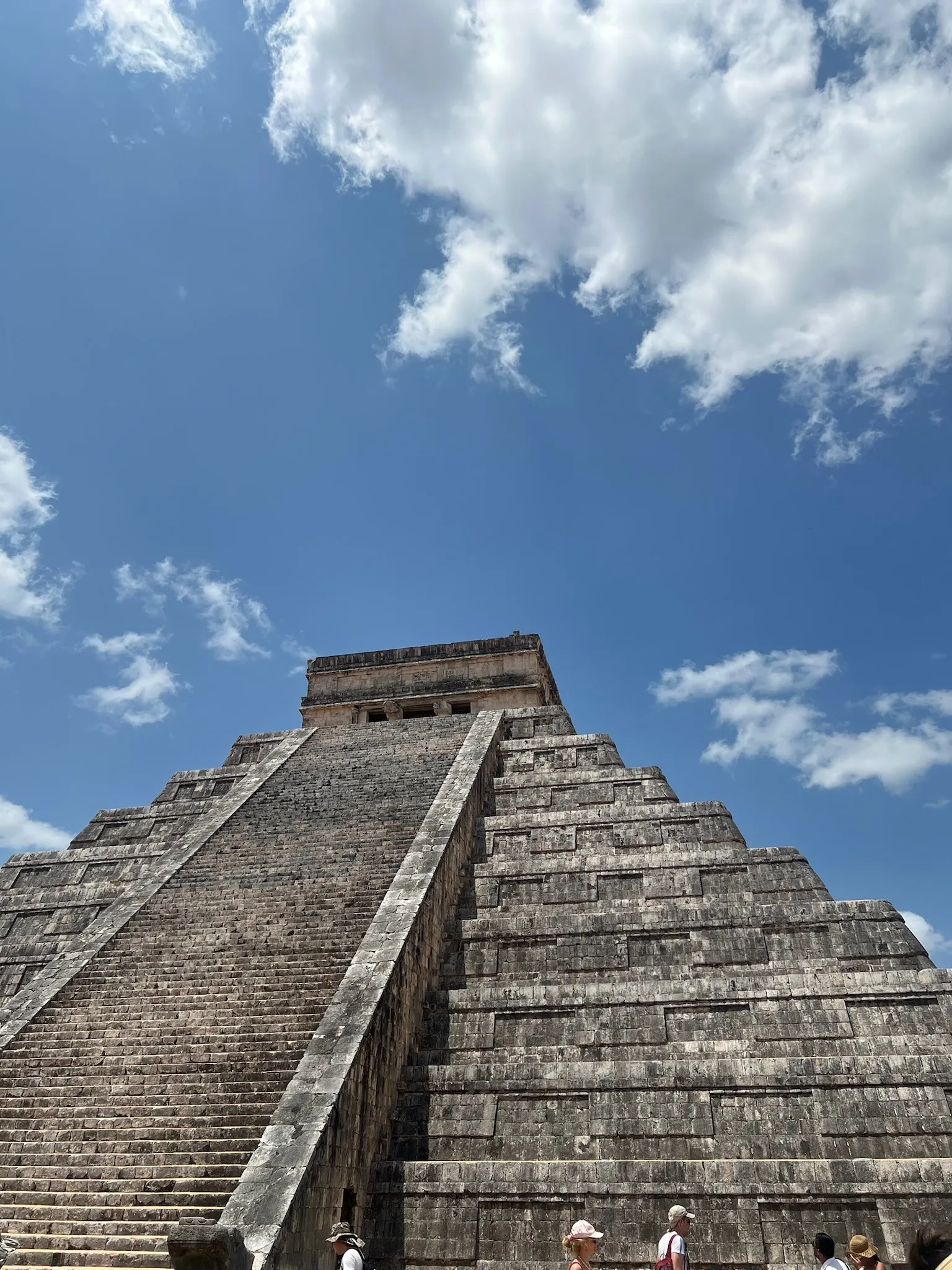 Looking up the stepped face of El Castillo at Chichen Itza against a bright sky