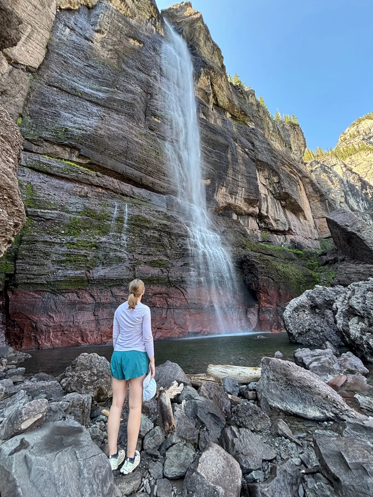 Standing on the boulders at the base of the tall falls