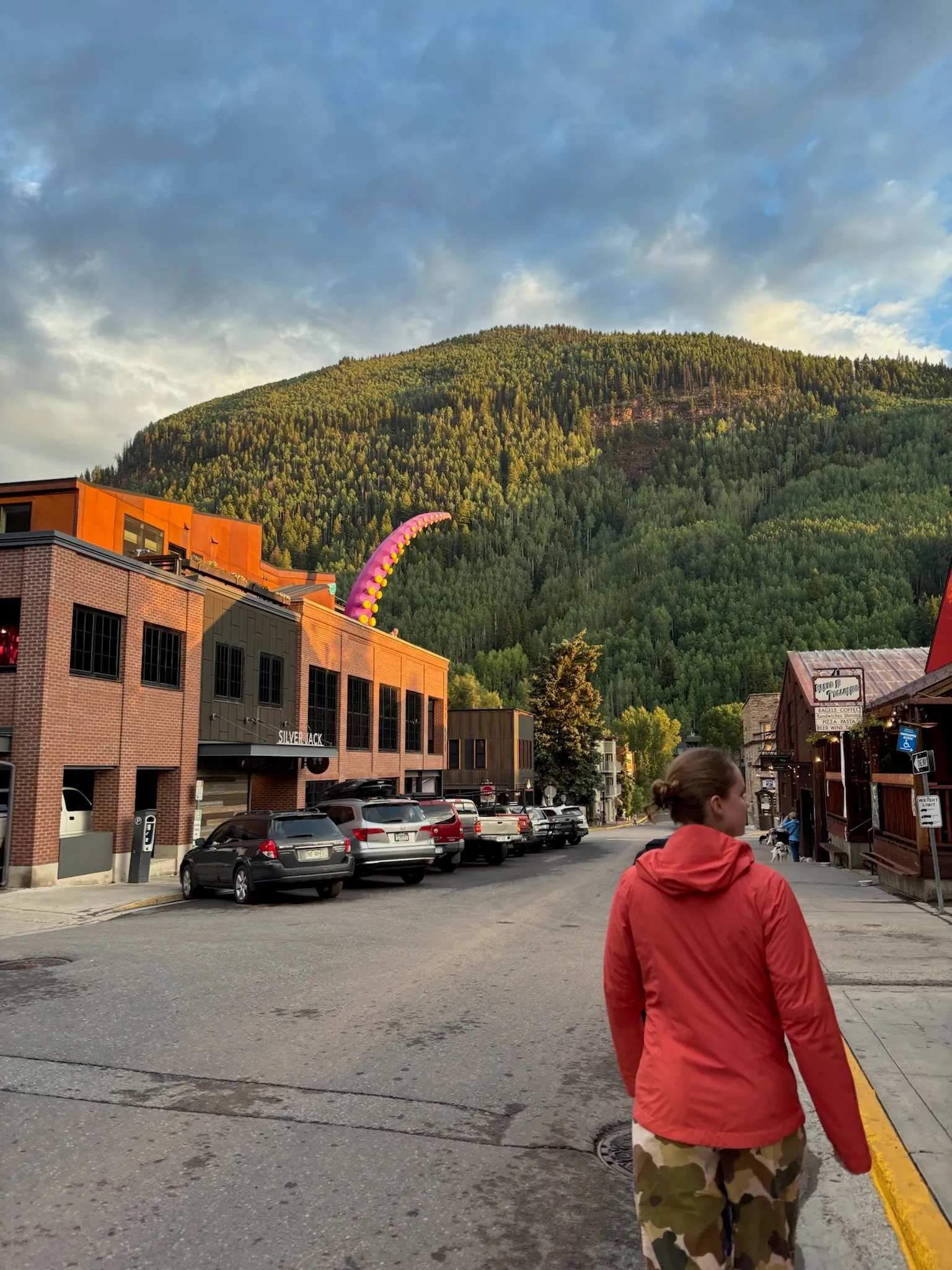 Walking down main street at dusk, the mountain rising at the end of the block