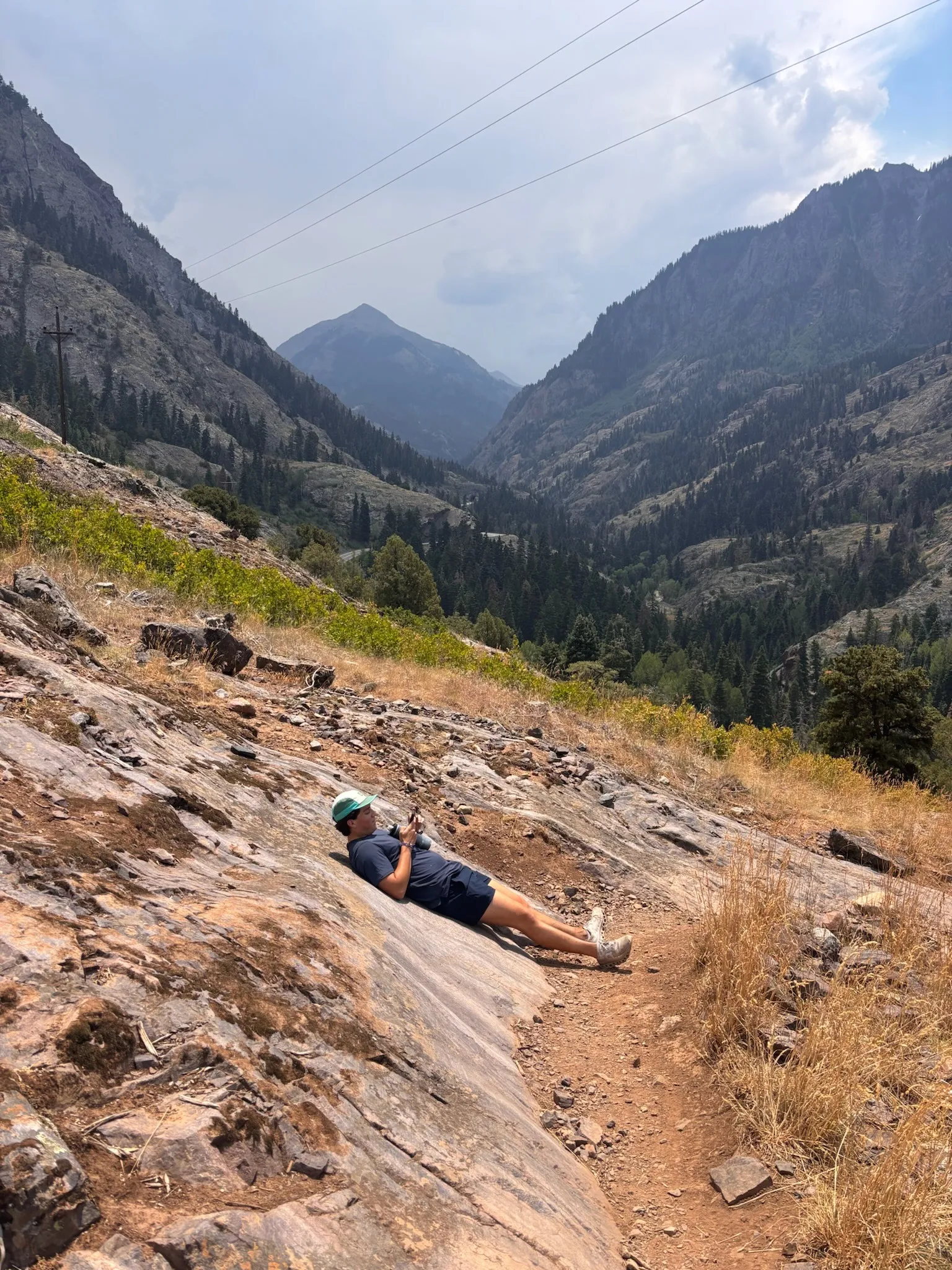 Lying back on a slab of red rock above the valley, peaks fading into the haze